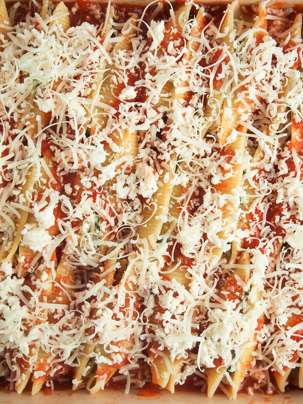 pulled pork stuffed shells with cheese over top ready to bake
