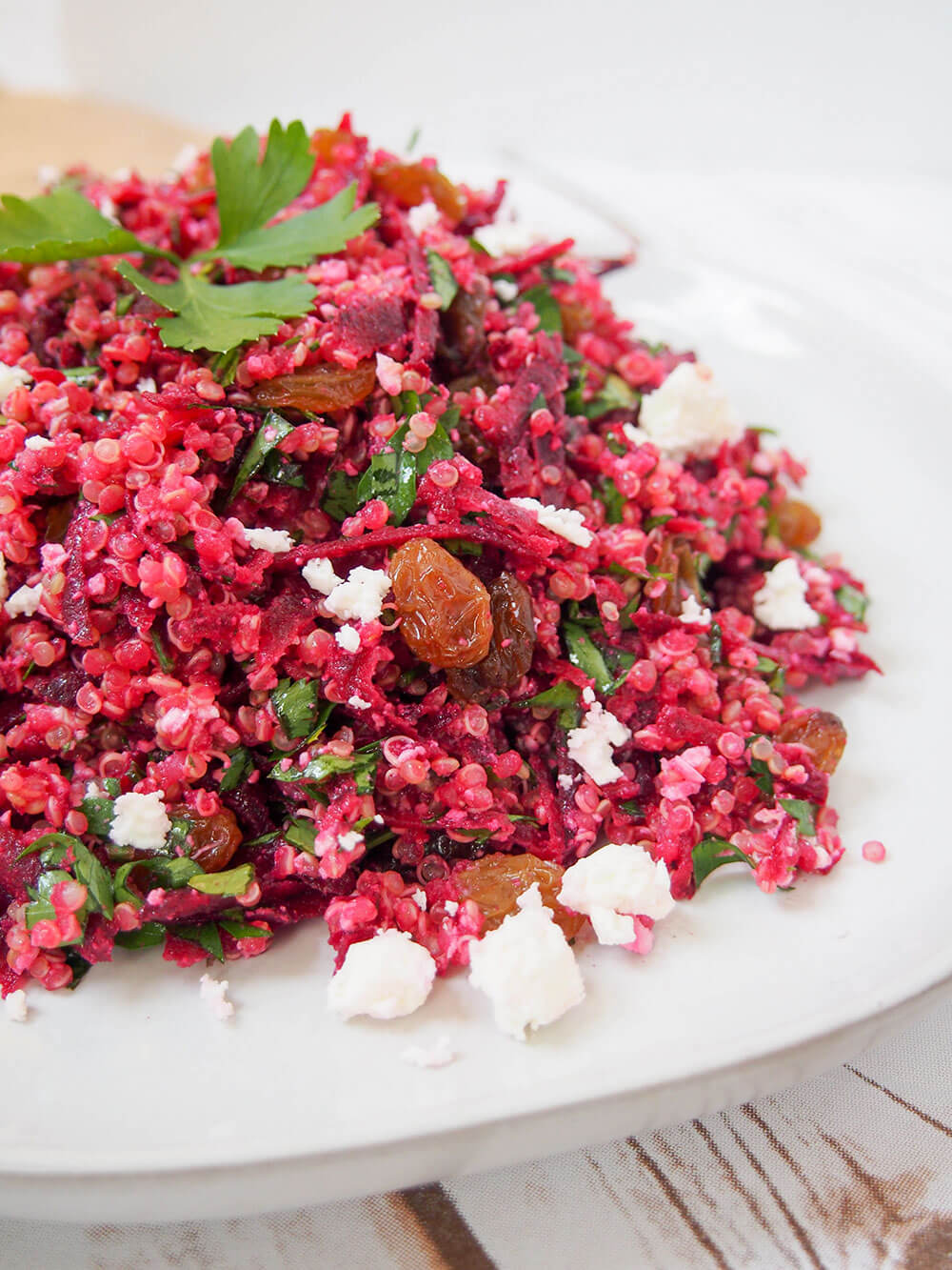 raw beet quinoa salad from side showing pieces of feta and raisins in it