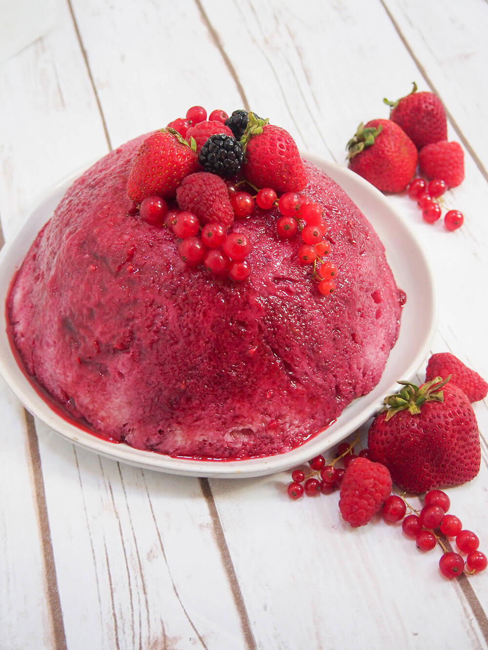 whole summer pudding topped with extra berries for decoration