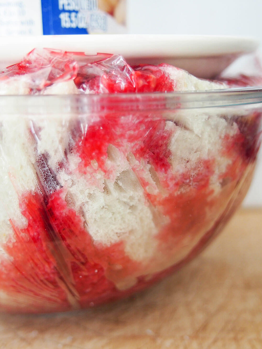 summer pudding being weighed down in bowl to bring out juices