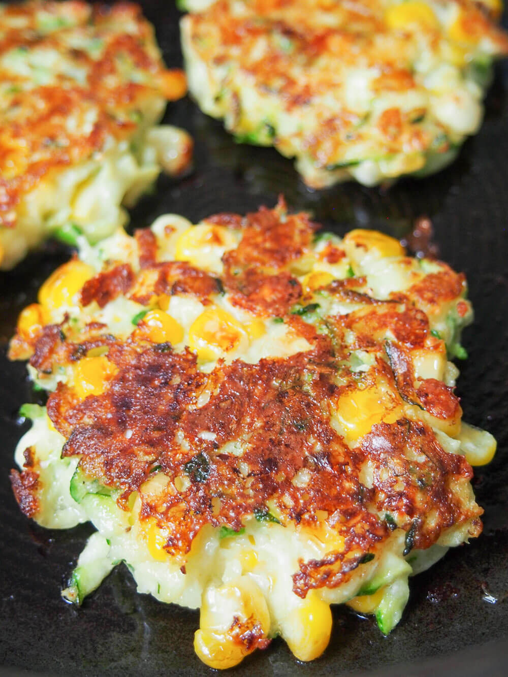 cooking zucchini corn fritters in skillet