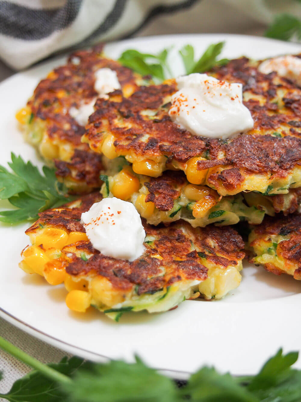 zucchini corn fritters on plate from the side