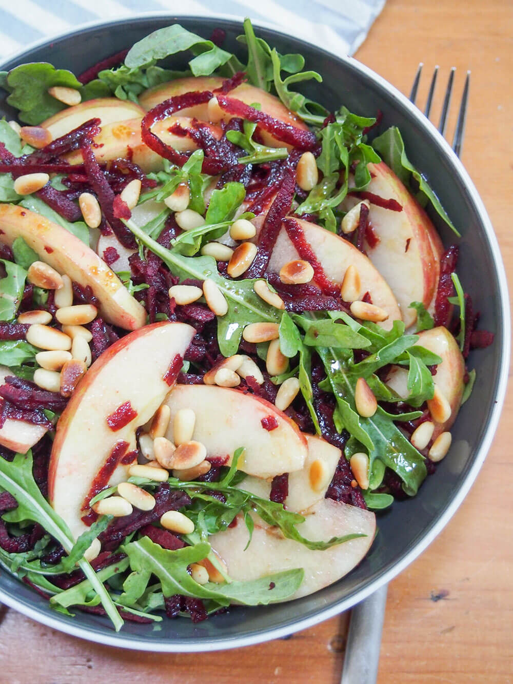 This beet apple salad with maple vinaigrette is incredibly easy to make and packed with autumnal flavor. Crunchy, flavorful and great as an appetizer or side. beet apple salad with maple vinaigrette from overhead with fork under bowl