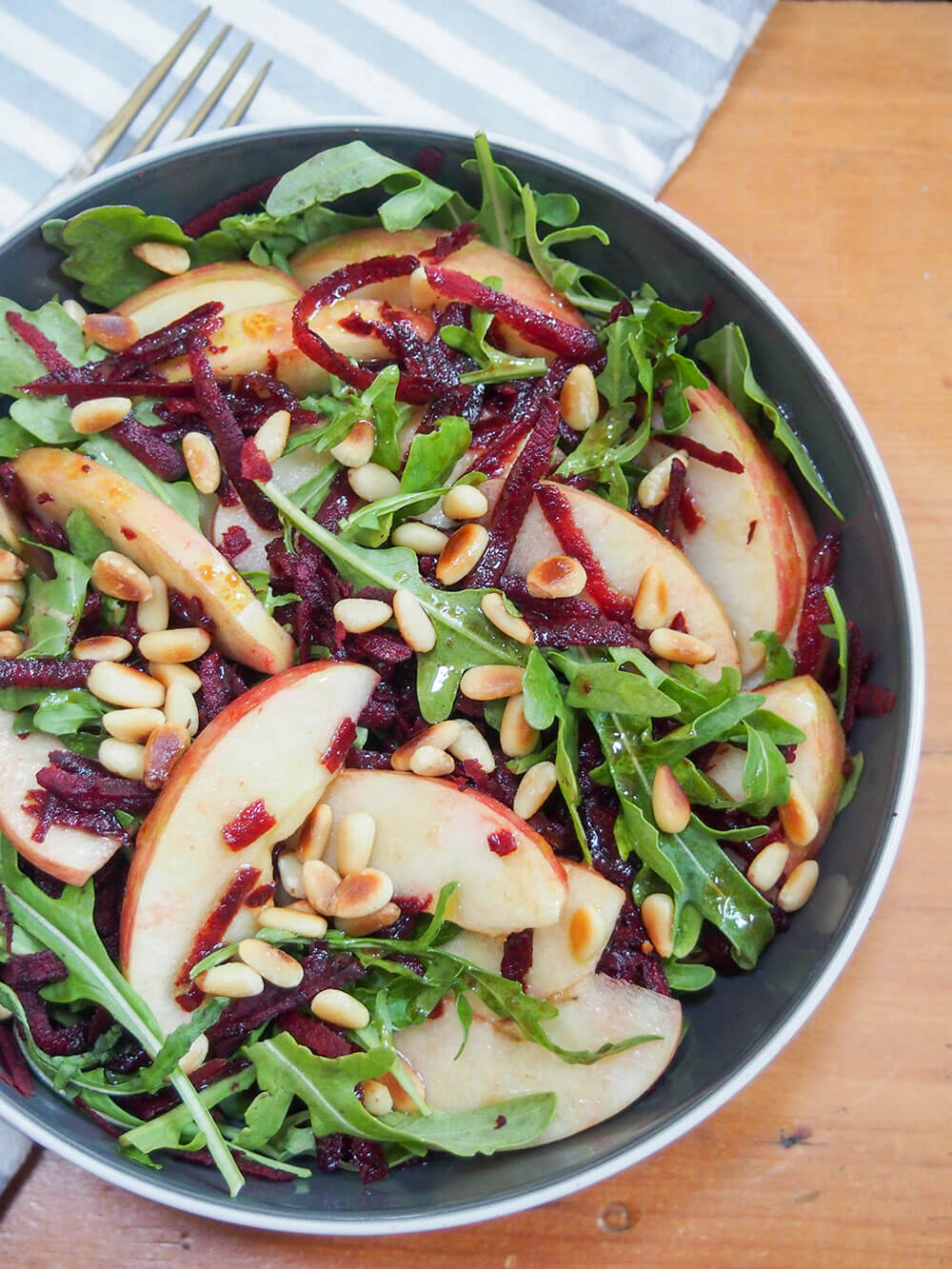 This beet apple salad with maple vinaigrette is incredibly easy to make and packed with autumnal flavor. Crunchy, flavorful and great as an appetizer or side. beet apple salad with maple vinaigrette in bowl from overhead
