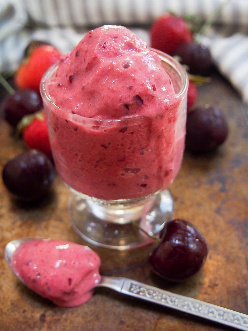 glass of cherry strawberry frozen yogurt with drip down front of glass