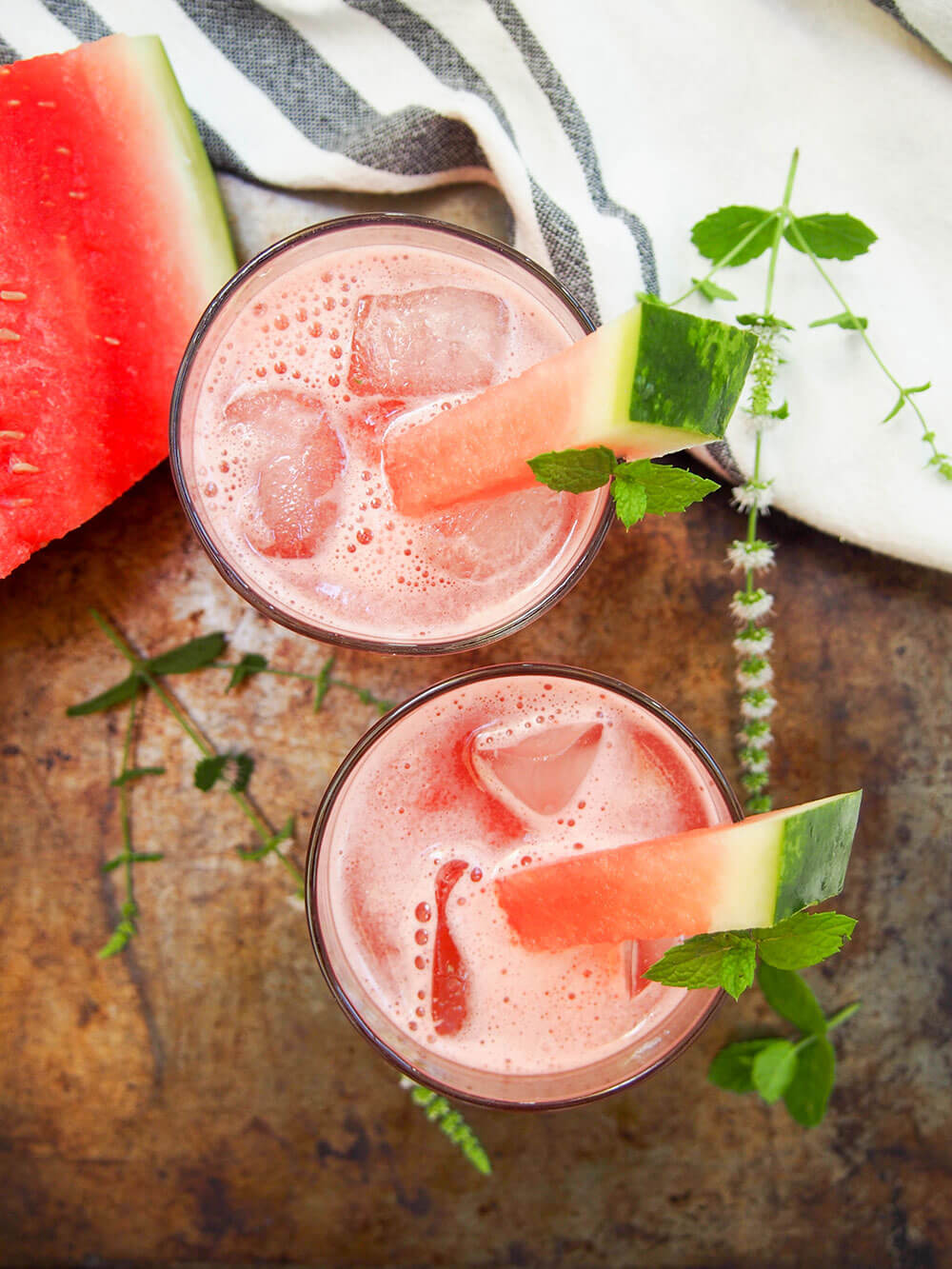 two glasses of watermelon coconut agua fresca viewed from above showing ice cubes in glass