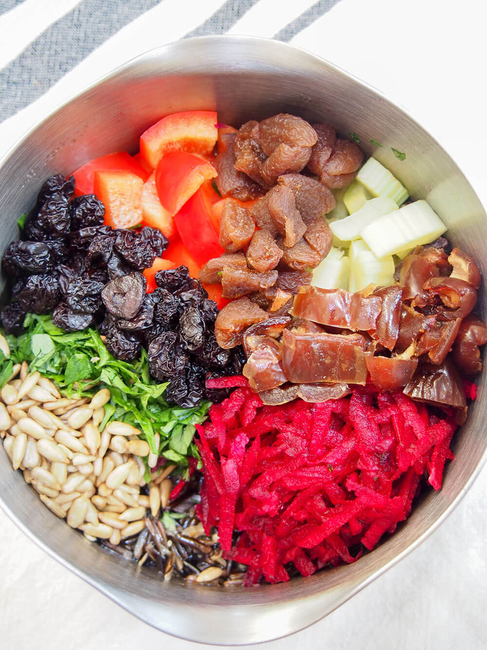 This wild rice salad is a wonderful combination of textures and flavors. A little tart from the vinaigrette, sweet from the dried fruit, with crunchy veg and tender fruit. And a whole lot of wholesome tastiness. wild rice salad ingredients ready to mix