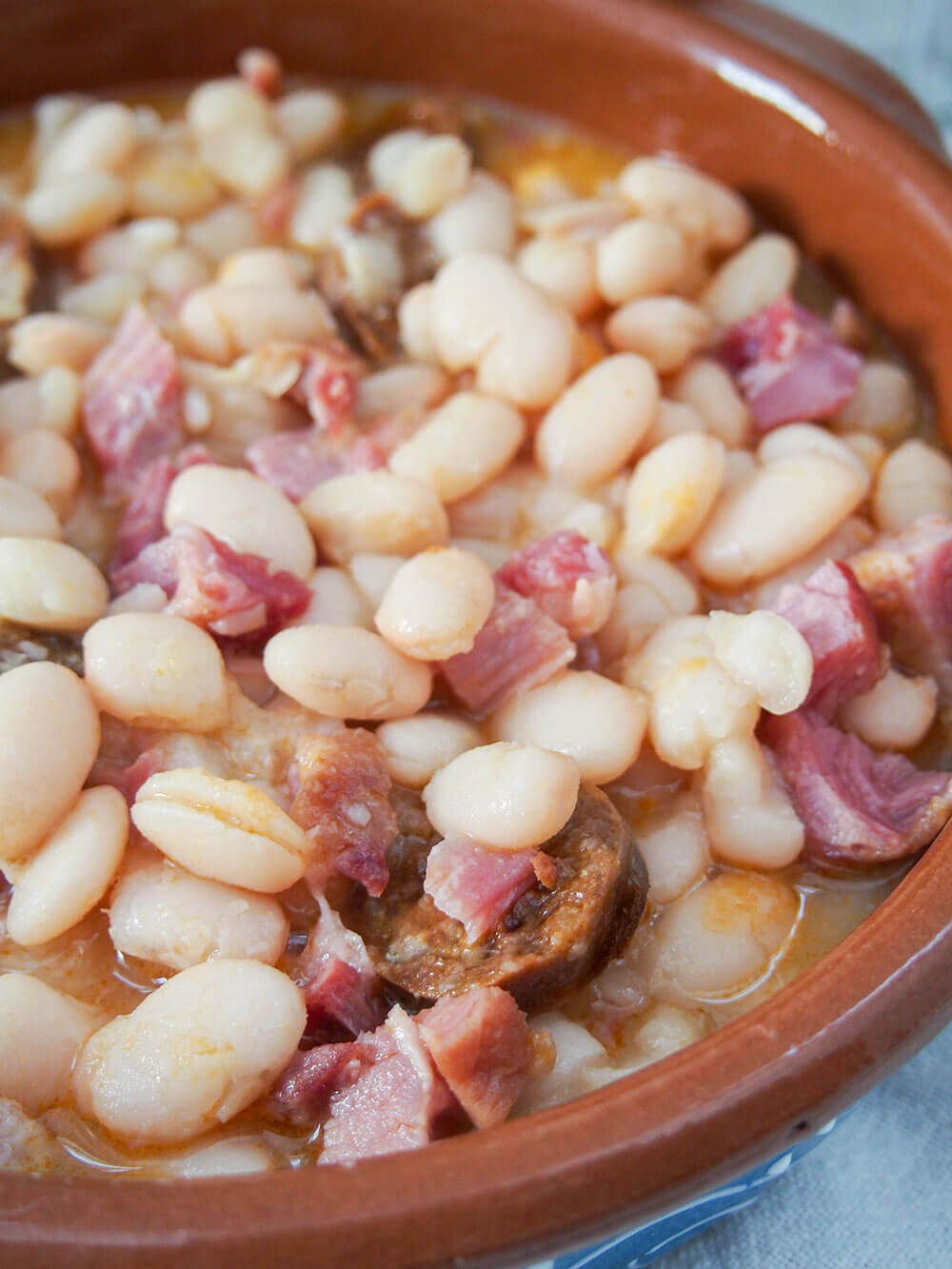 Fabada Asturiana - Asturian white bean stew - close up in serving dish