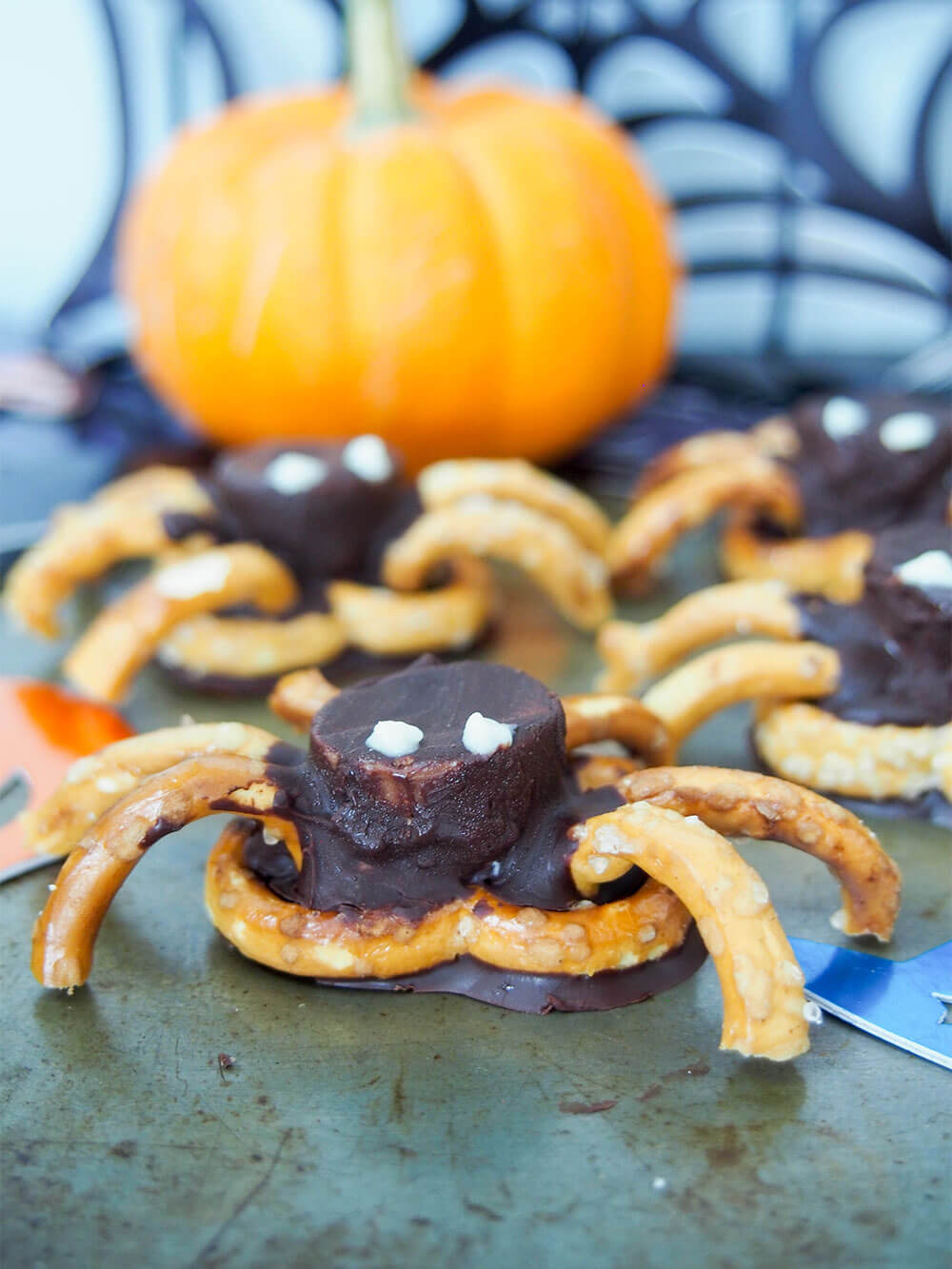 close up of chocolate pretzel spider with more behind