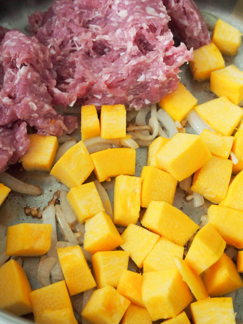 adding pork and pumpkin to pan