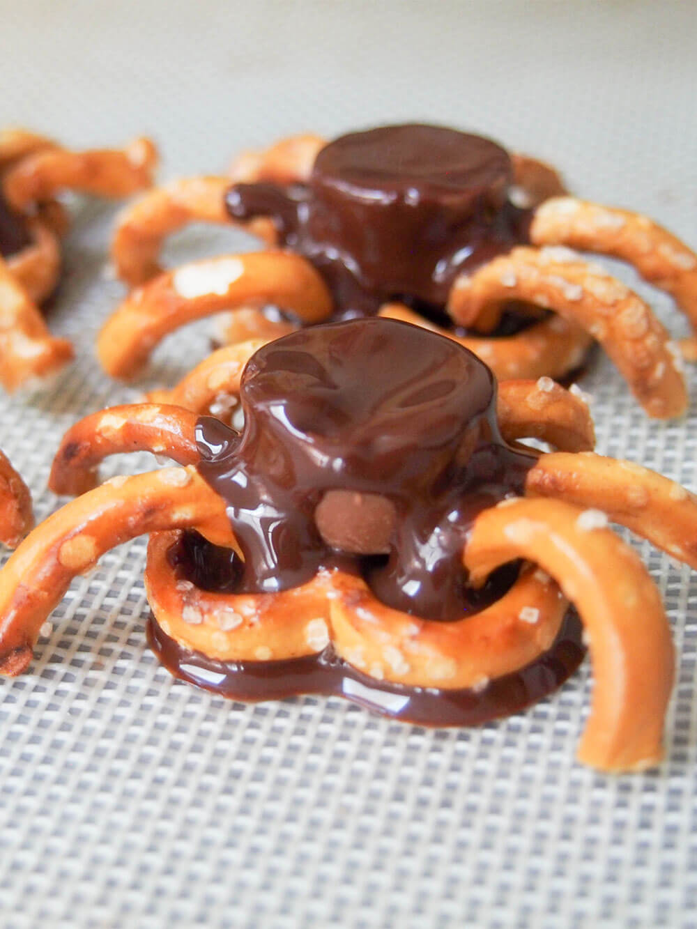 making chocolate pretzel spiders - adding pretzel legs