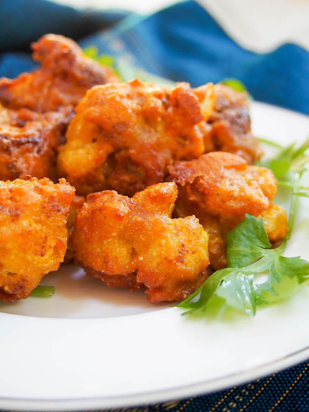 Cauliflower pakora are a traditional Indian snack or appetizer that are quick, tasty and versatile. Cook up some of these fritters to start your next Indian meal or add some to your game day or party menu! Close up of cauliflower pakora