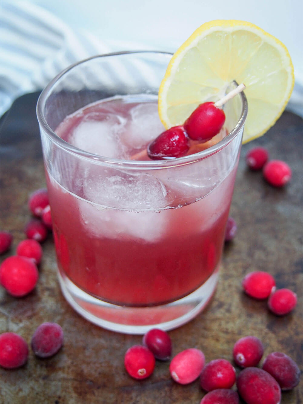 cranberry whiskey sour with lemon and cranberry garnish