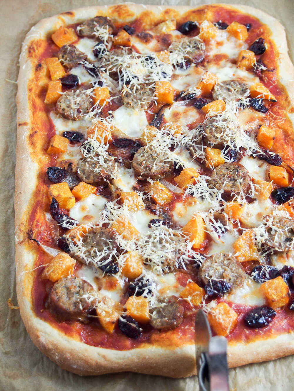 about to cut fall pizza with sausage and squash