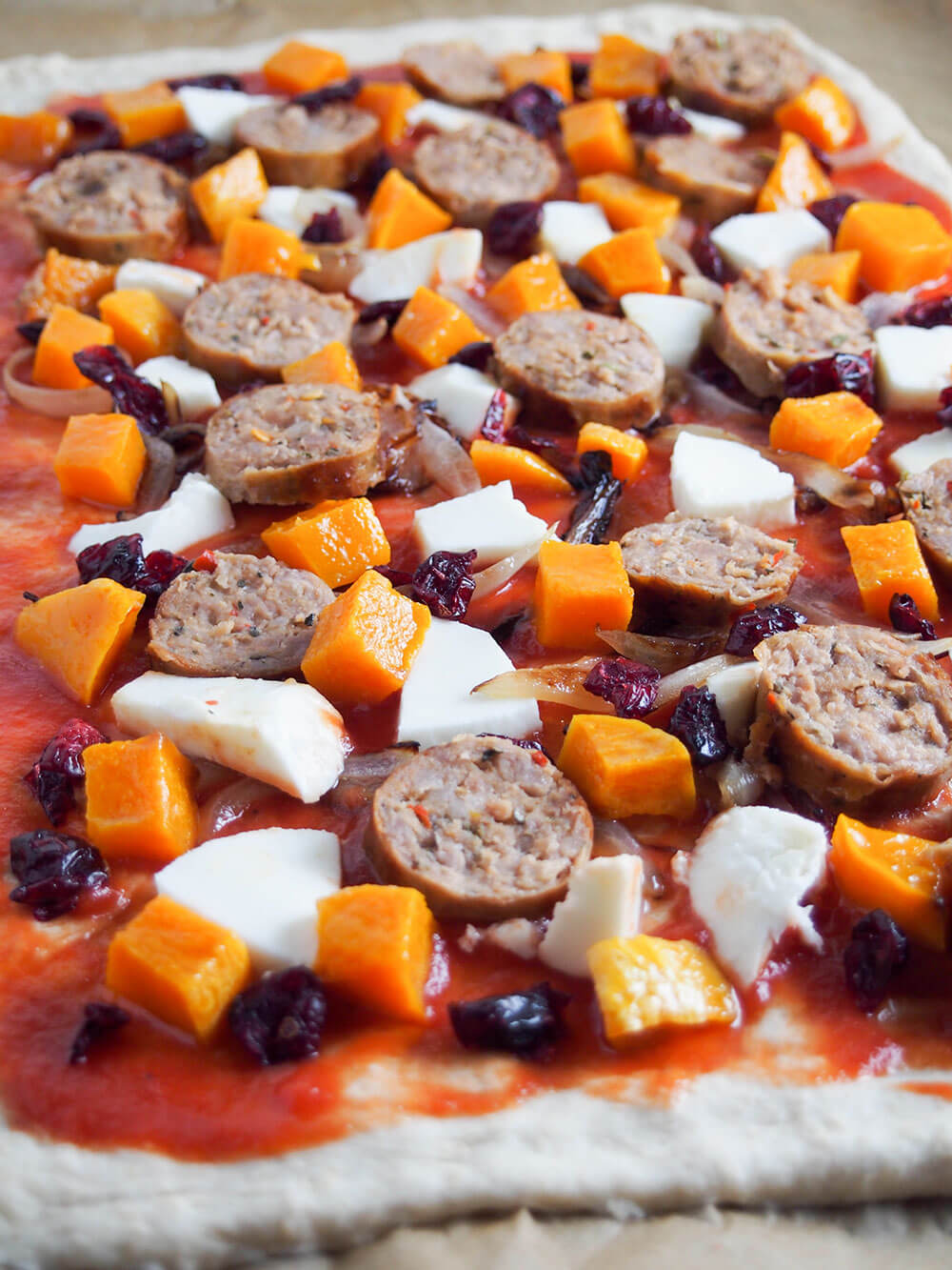 adding toppings to pizza