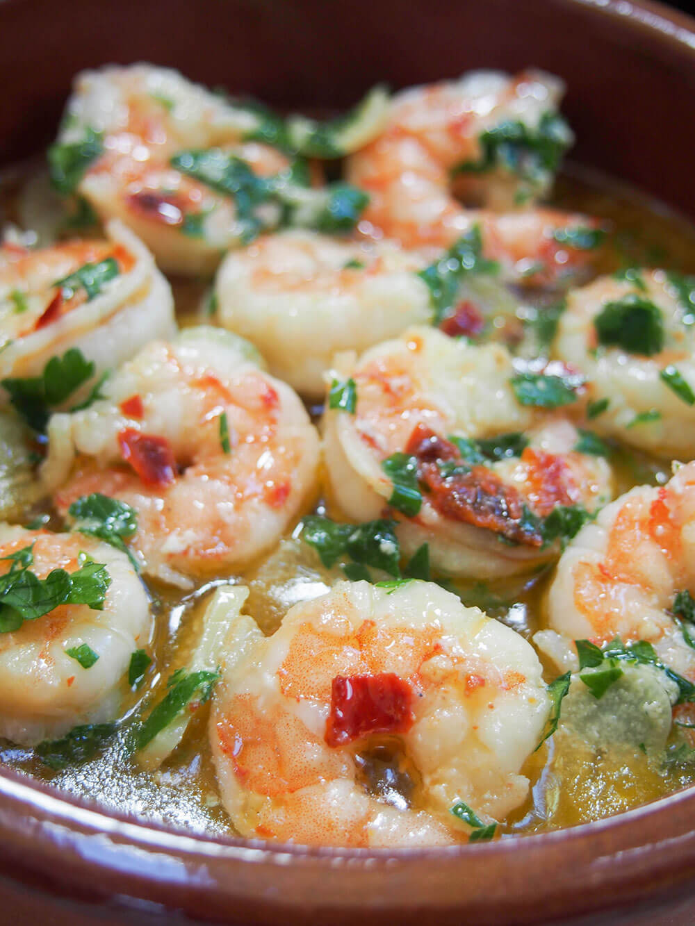 Gambas al ajillo (Spanish garlic shrimp) in serving dish viewed from side
