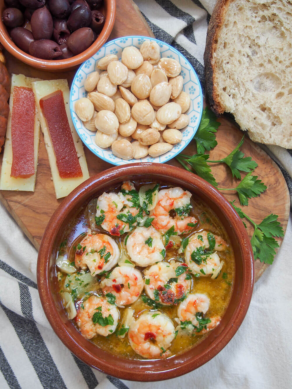 Gambas al ajillo (Spanish garlic shrimp) served with Spanish almonds, cheese with membrillo, olives and bread