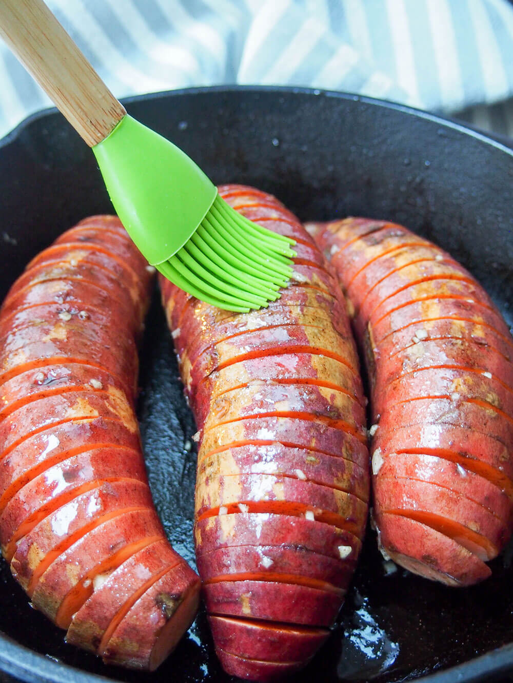 brushing hasselback sweet potatoes with maple-oil mixture