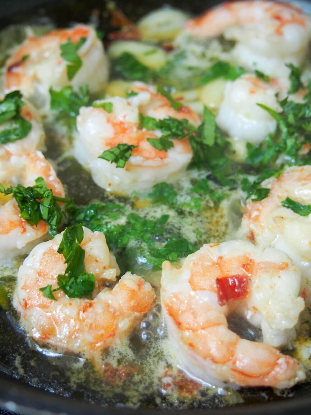 adding parsley to shrimp at end of cooking