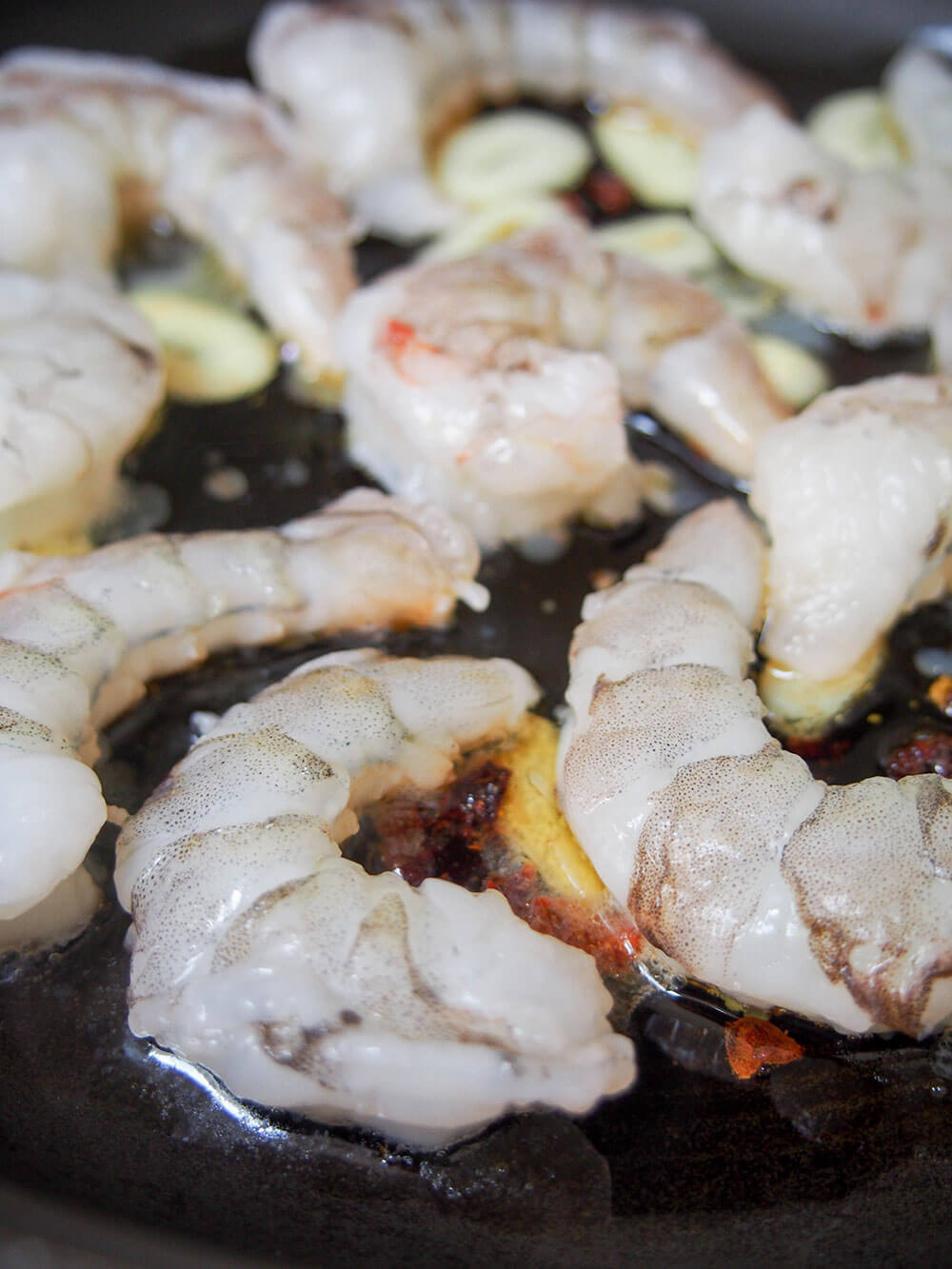 adding shrimp to cook in garlic-chili oil