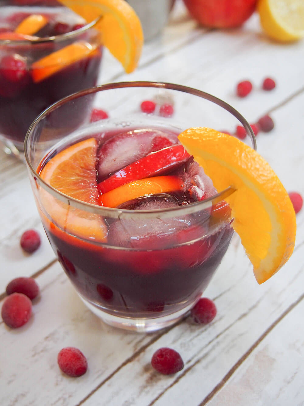 glass of cranberry sangria with orange garnish on glass