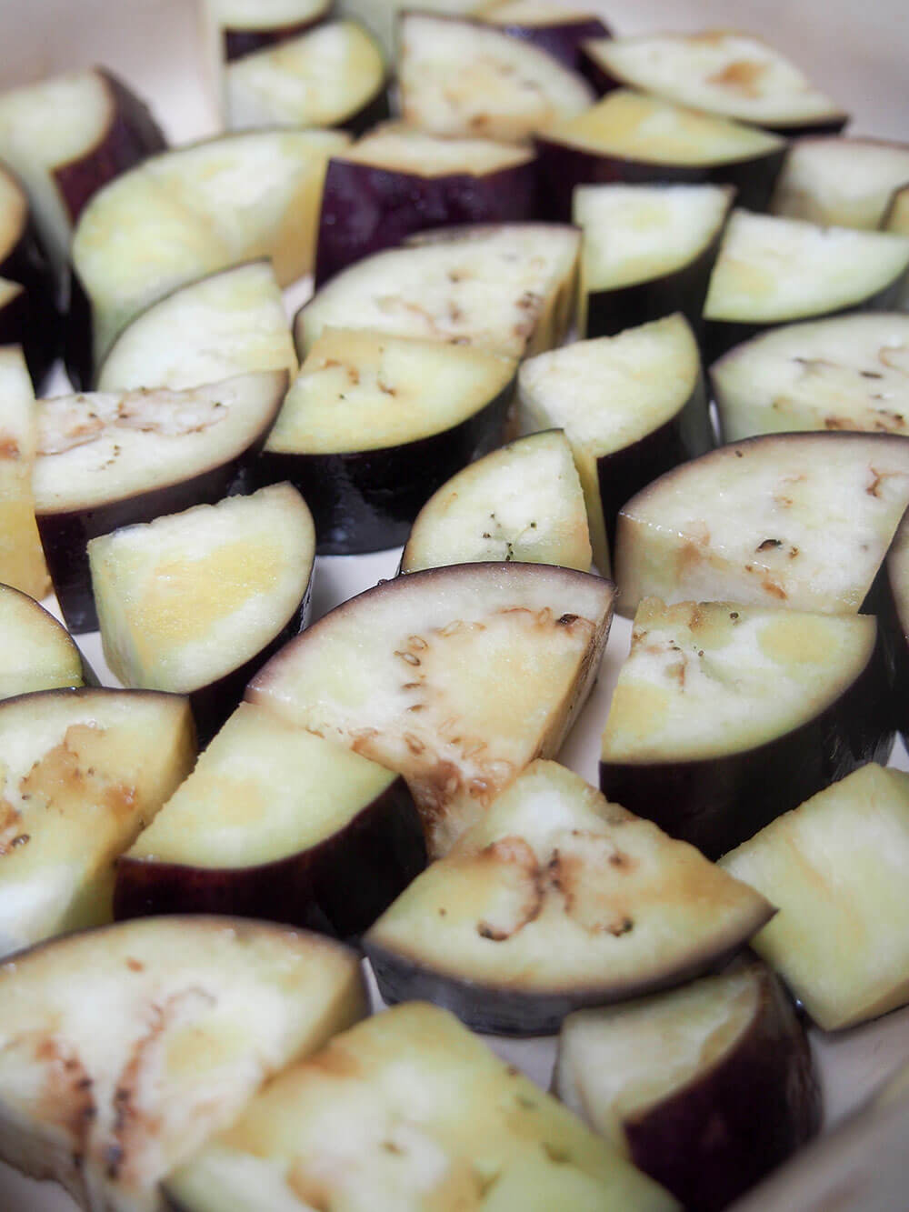 eggplant drizzled with oil in baking dish ready to roast