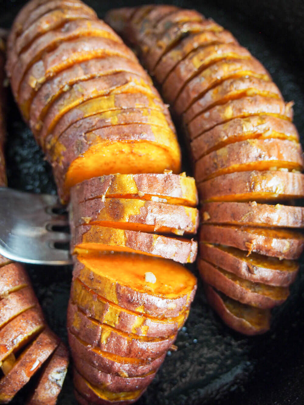 hasselback sweet potatoes - lifting one up with fork