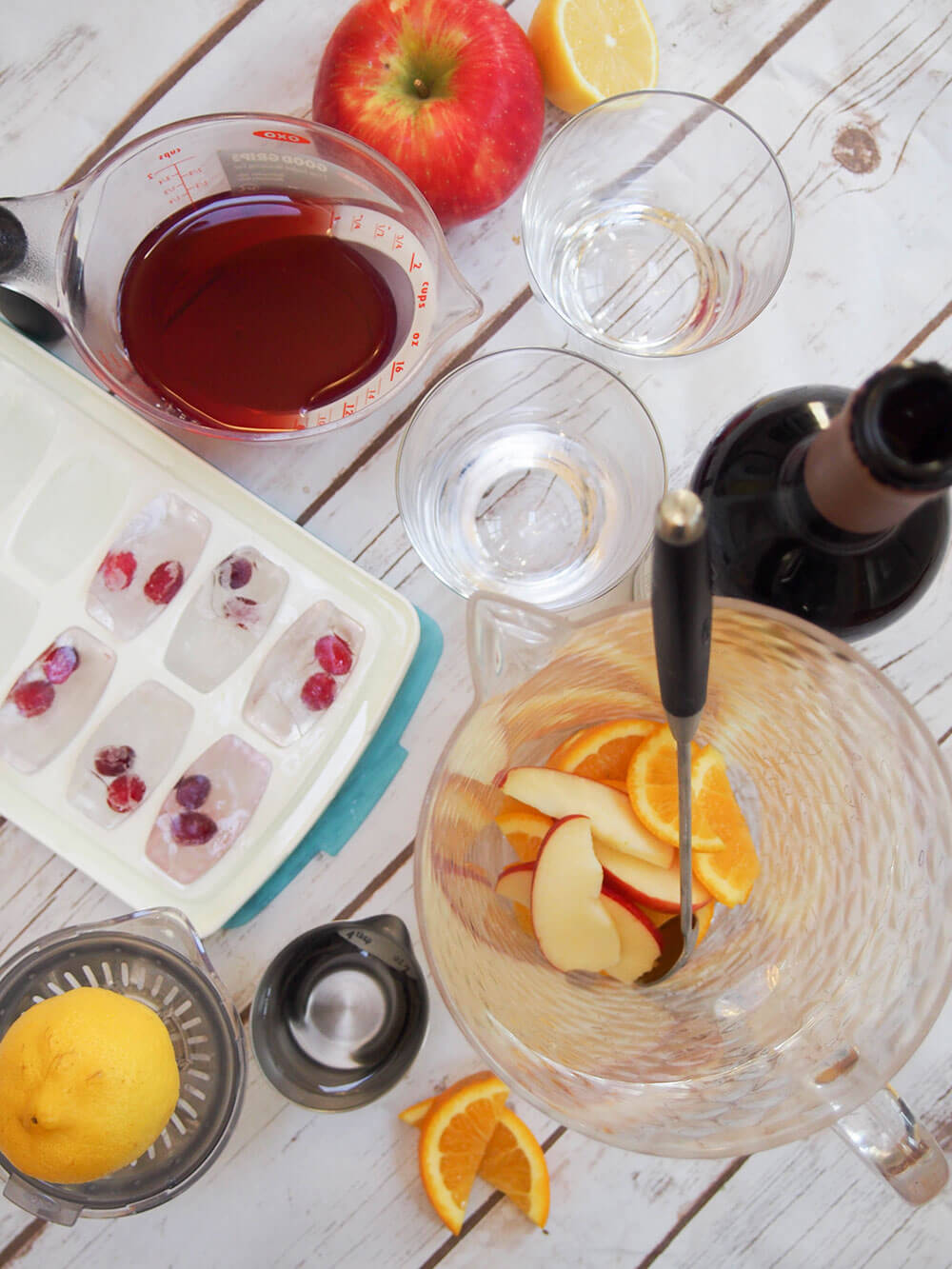 fruit in jug, ice cubes, glasses, juicer and wine ready to put together