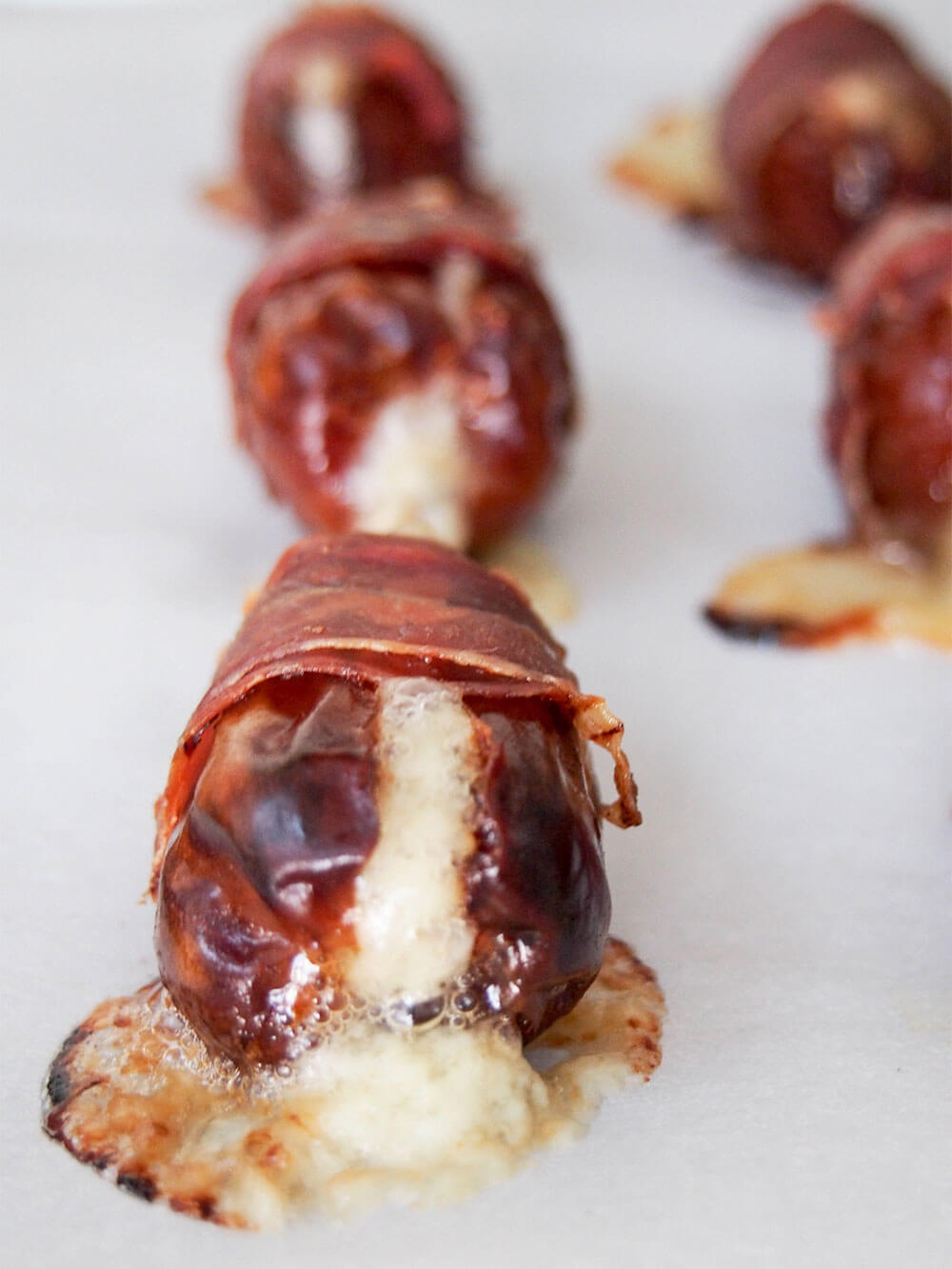 prosciutto wrapped dates just out the oven with some cheese oozing out