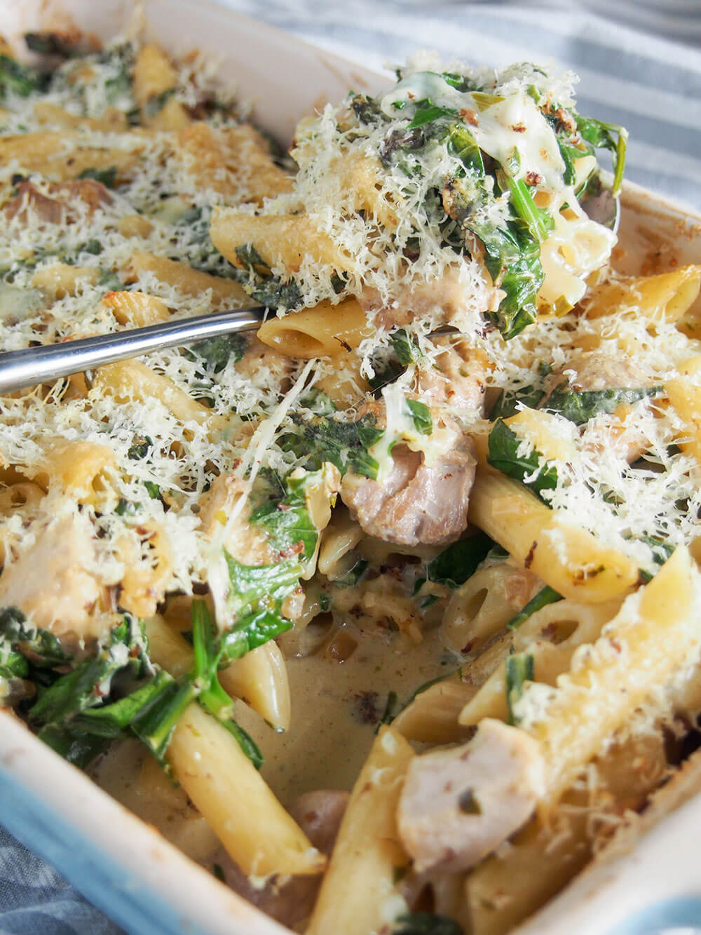 This creamy lemon chicken pasta bake has so much tastiness going on from the tarragon lemon cream sauce that wraps together the pasta, chicken and spinach. Creamy lemon chicken pasta bake with spoonful resting on top
