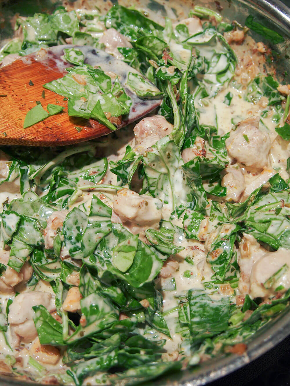 making sauce for Creamy lemon chicken pasta bake making creamy sauce with chicken and spinach as base