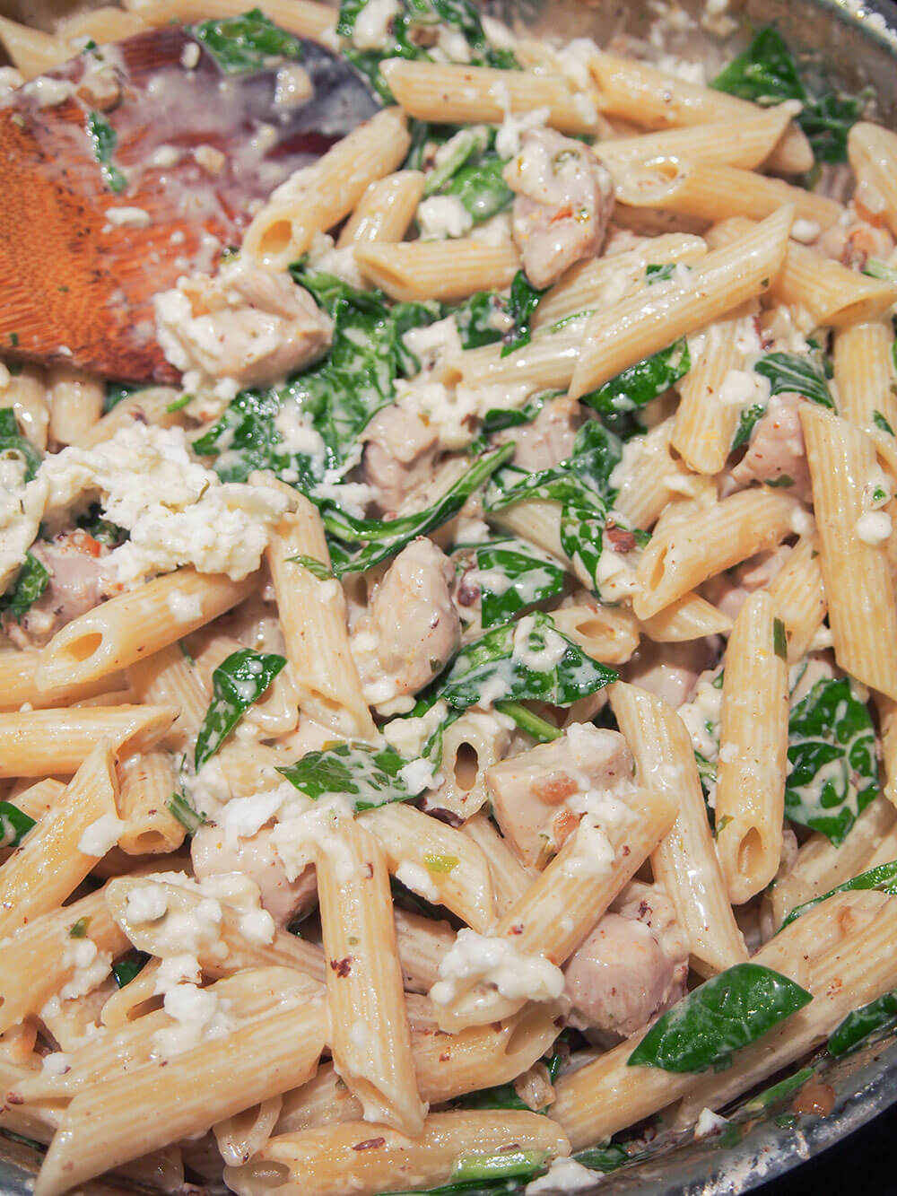making creamy lemon chicken pasta bake adding pasta into sauce