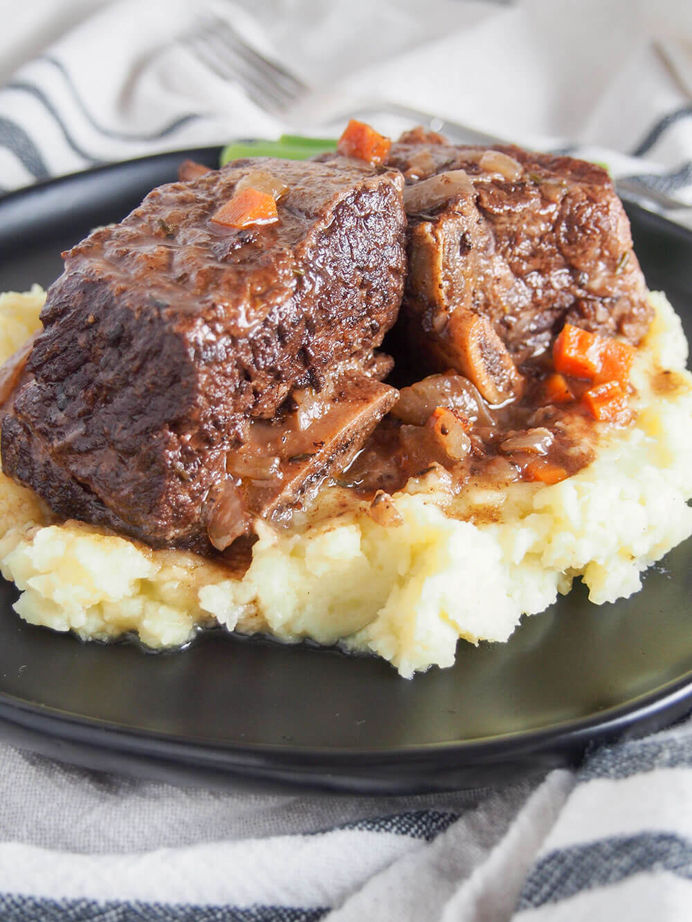 These slow cooker short ribs are easy to prepare, fall-off-the-bone tender and packed with flavor after testing for the perfect set of ingredients. So good. slow cooker short ribs over mashed potato close up