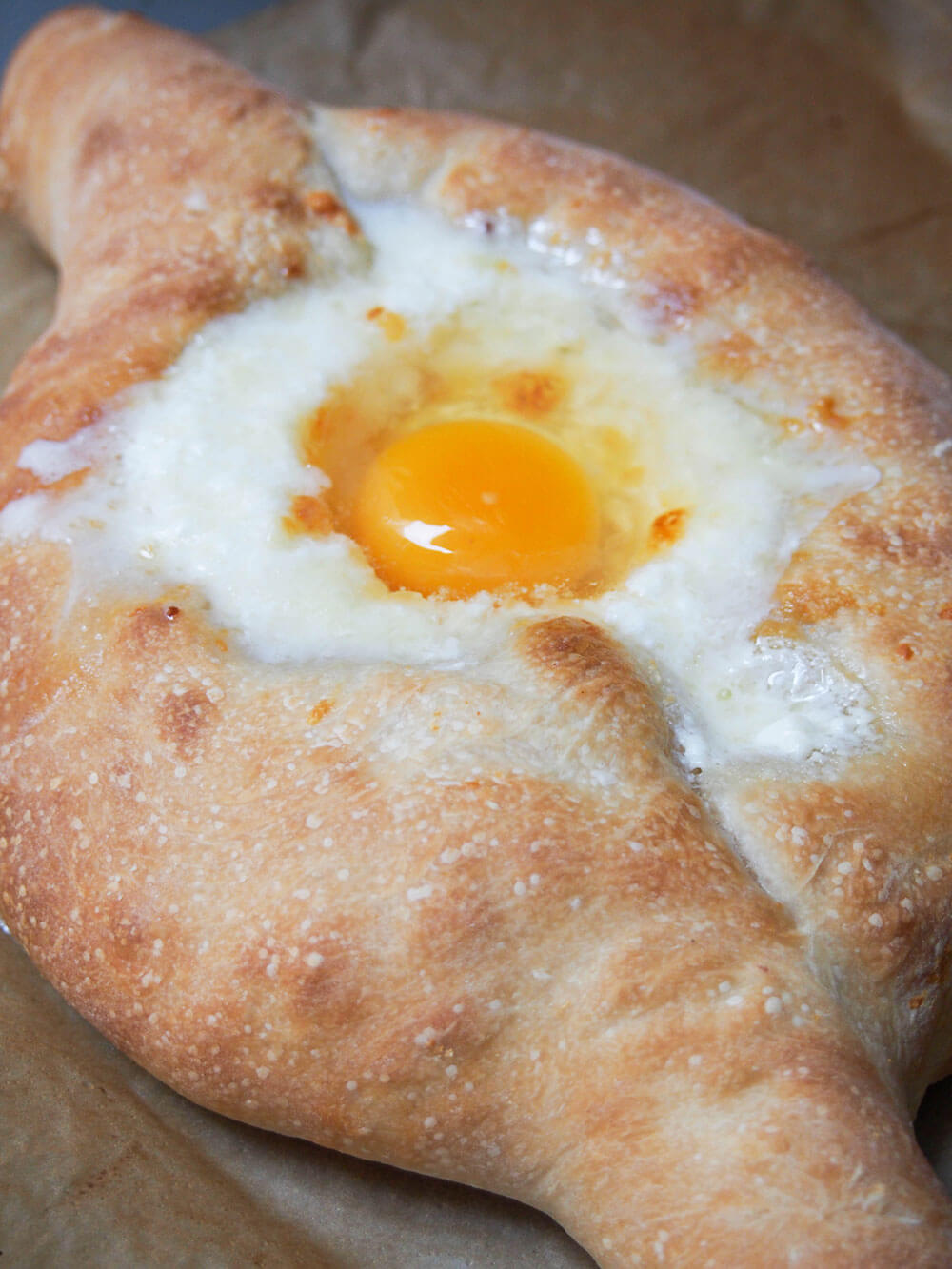 adding egg to middle of cheese filling in Adjaruli khachapuri 