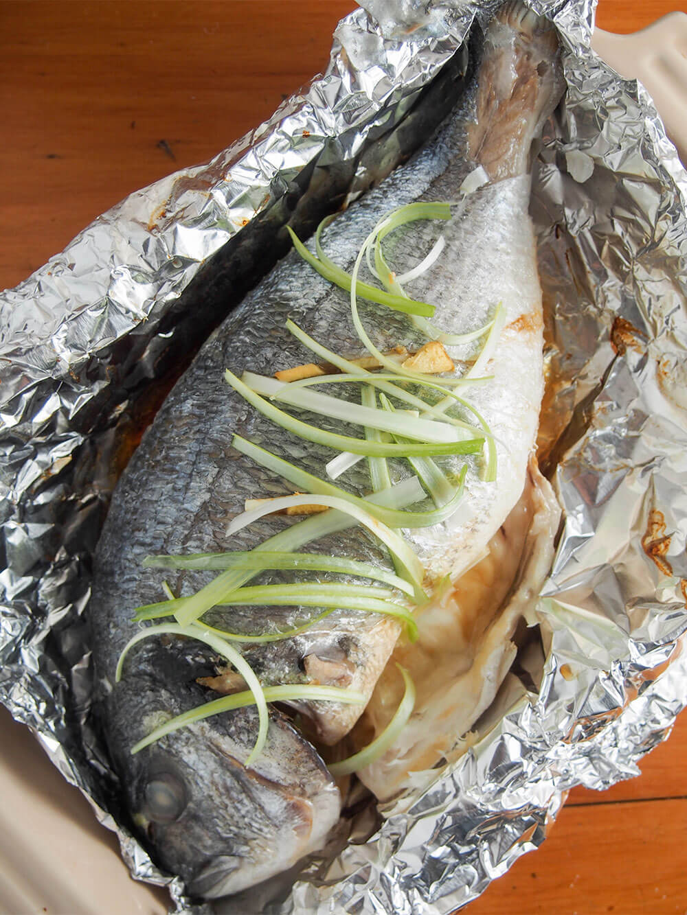 Chinese oven steamed fish sitting in foil from overhead