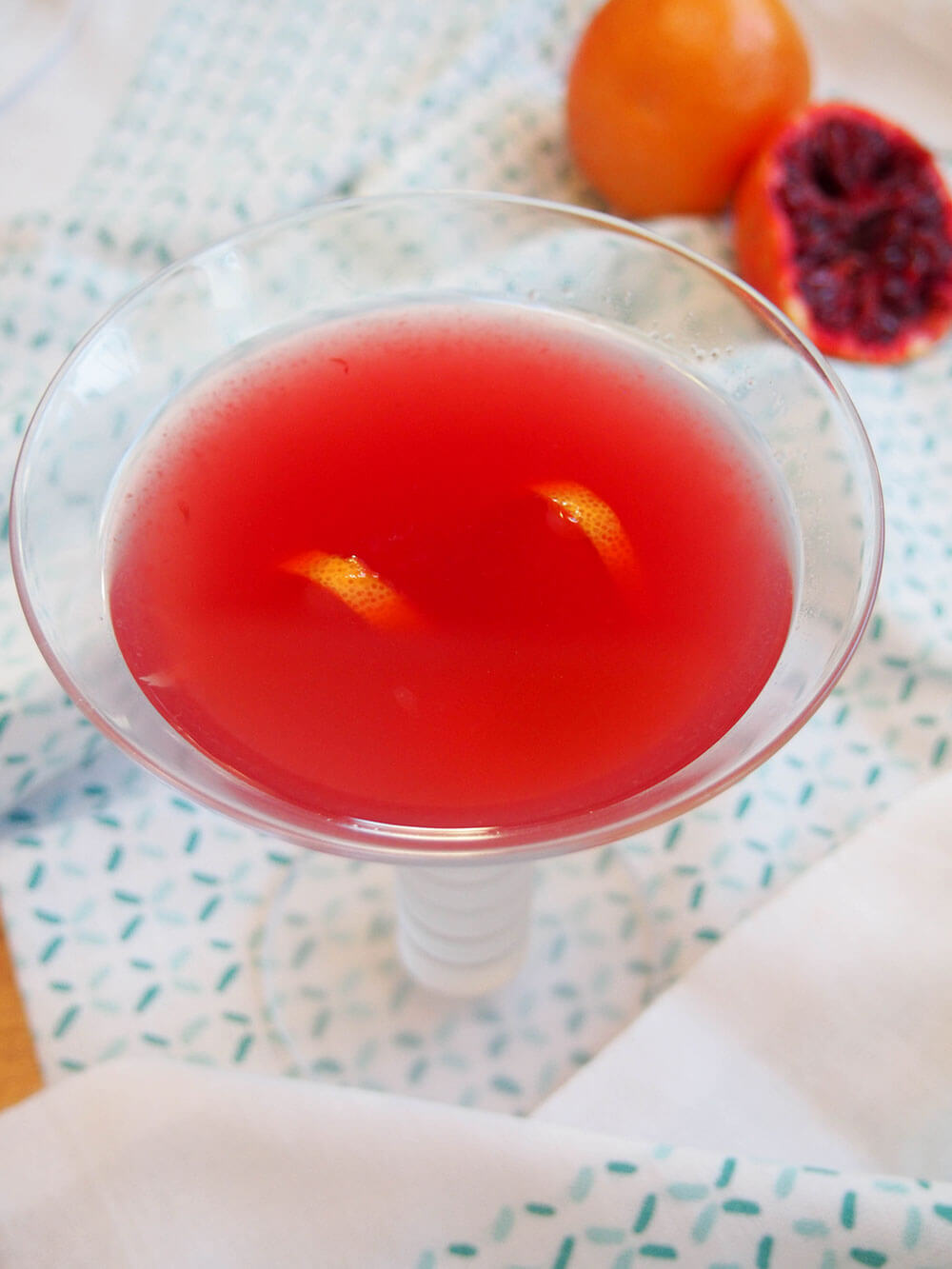 blood orange bees knees cocktail with blood orange behind