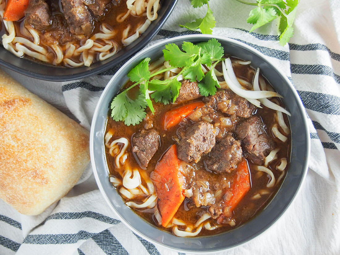 Bo kho may not be as well known as pho, but it's a classic dish you need to get to know. This Vietnamese beef stew has a wonderful depth of flavor from aromatic spices, lemongrass, ginger and coconut water. It's warming, delicious and easy to make too. bowl of bo kho Vietnamese beef stew with bread to side