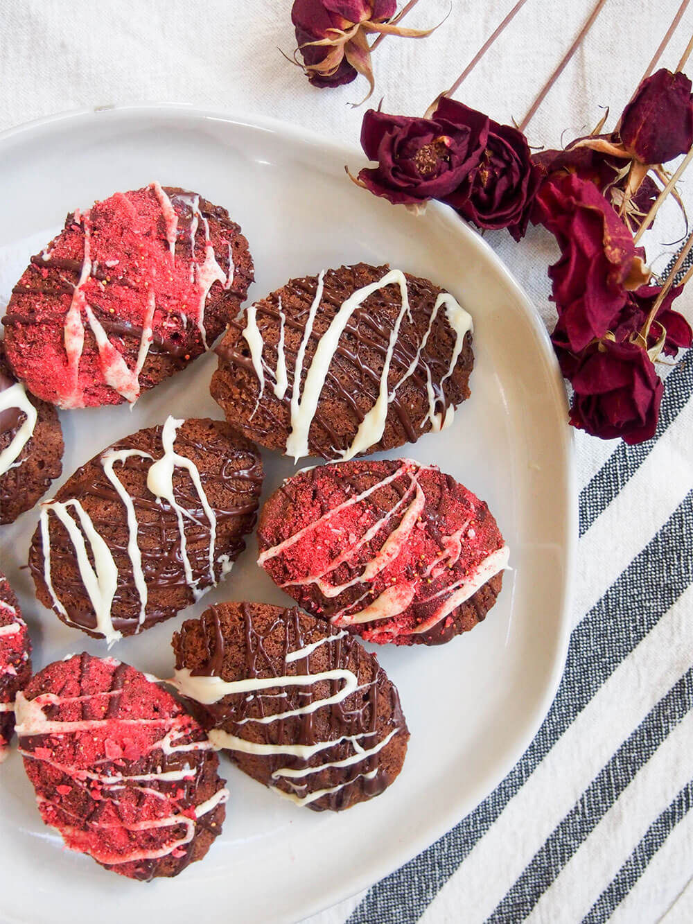 chocolate madeleines on plate from overhead with roses to side