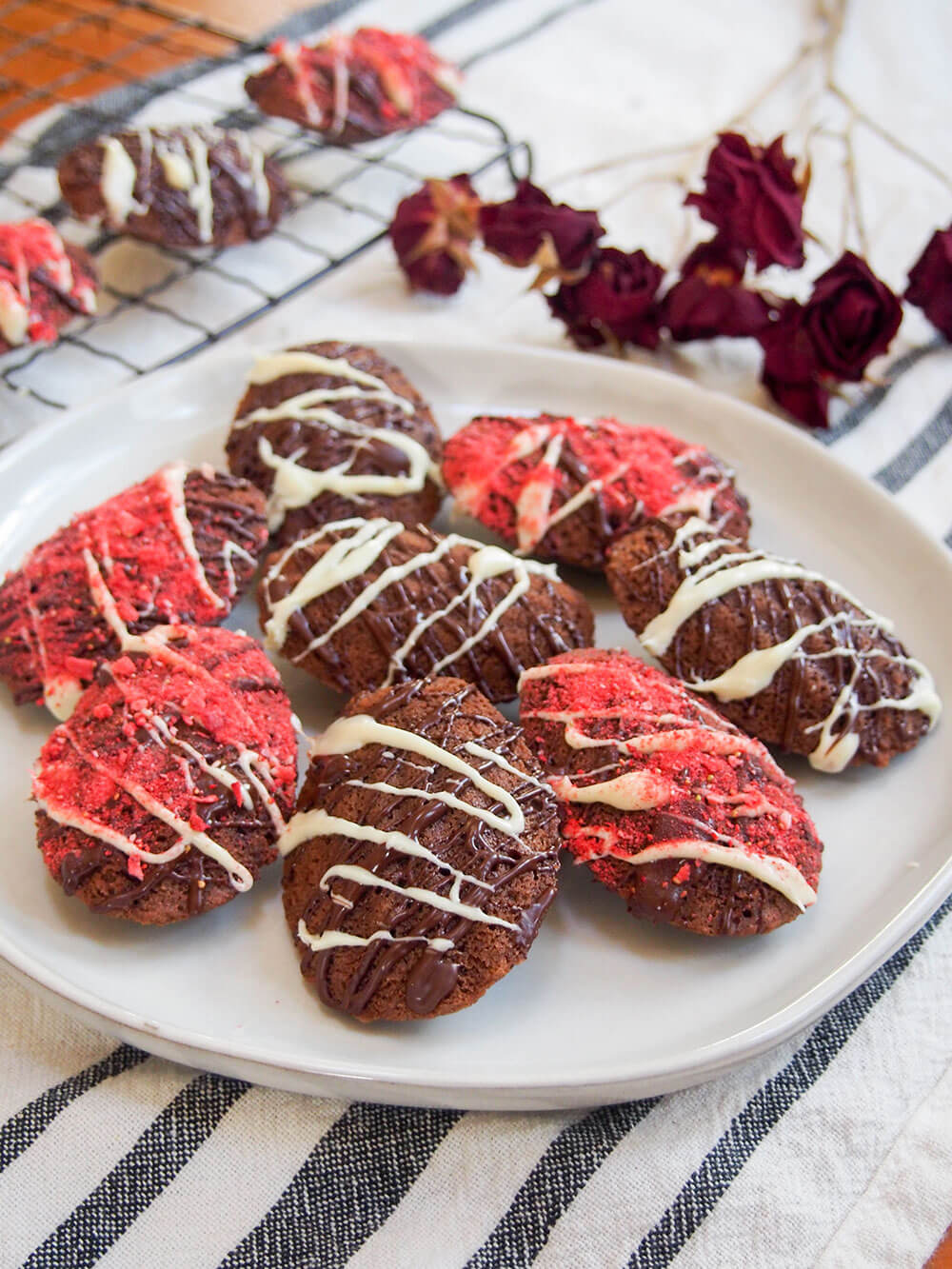 chocolate madeleines on plate with roses behind