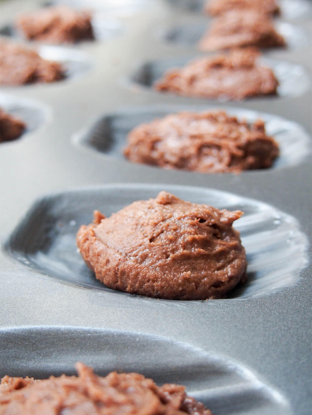 chocolate madeleine batter in mould ready to bake