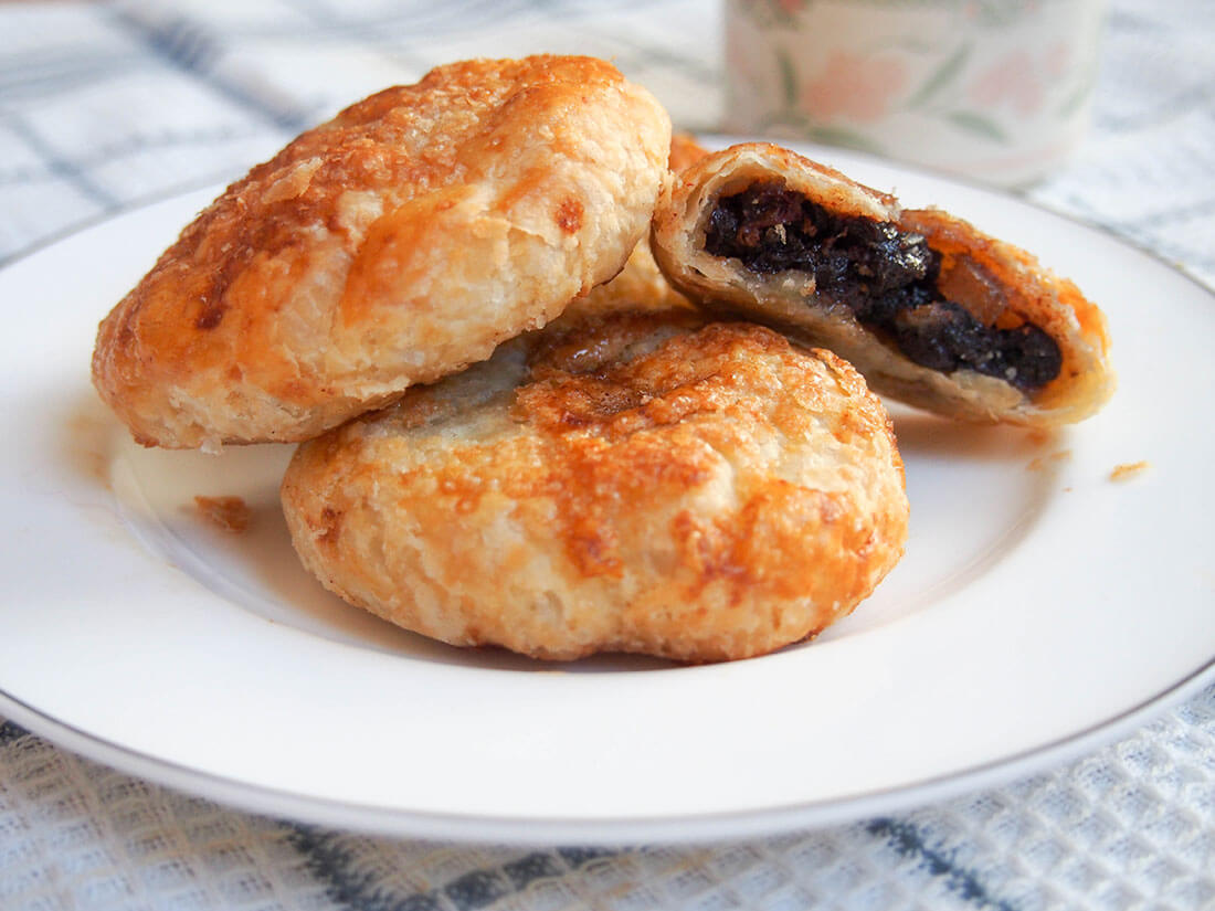 Eccles cakes - crisp currant filled pastries Eccles cakes, British currant pastries, on plate