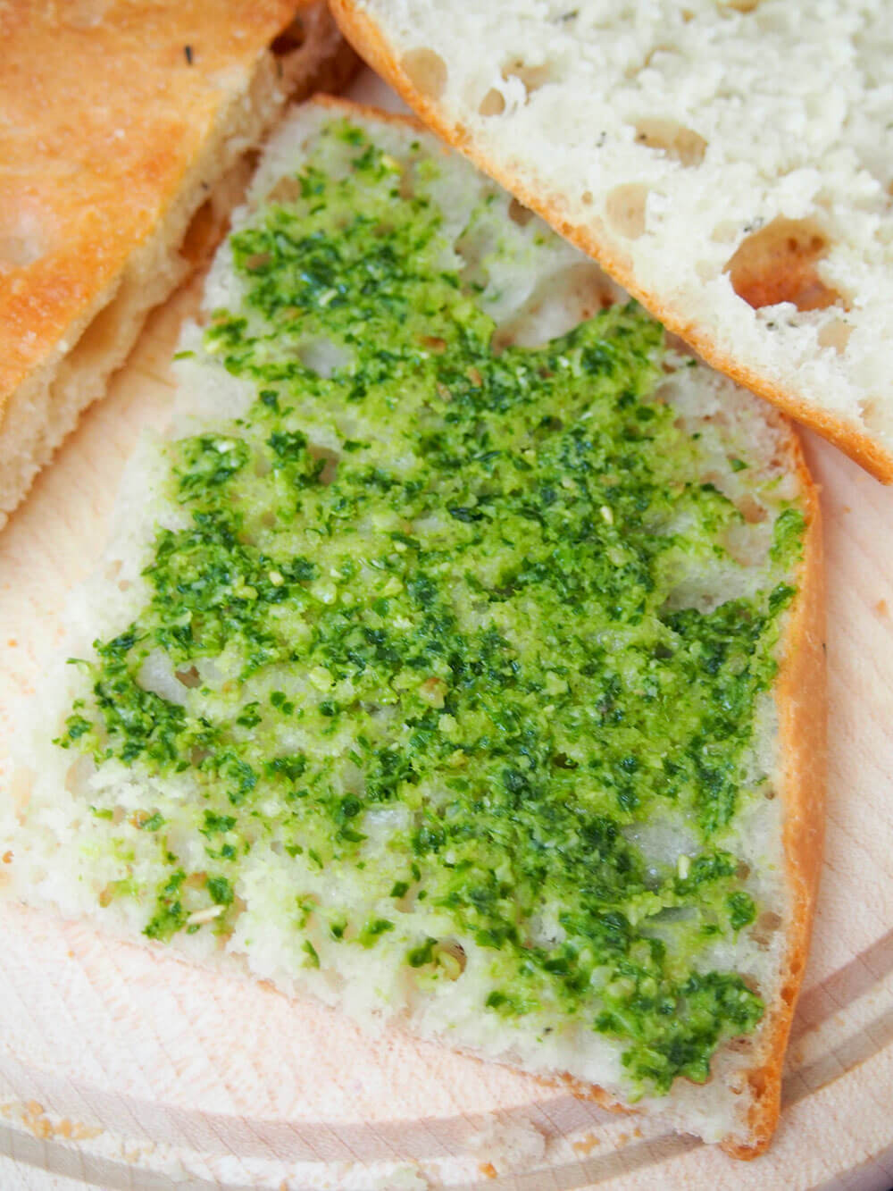 spreading pesto on focaccia base
