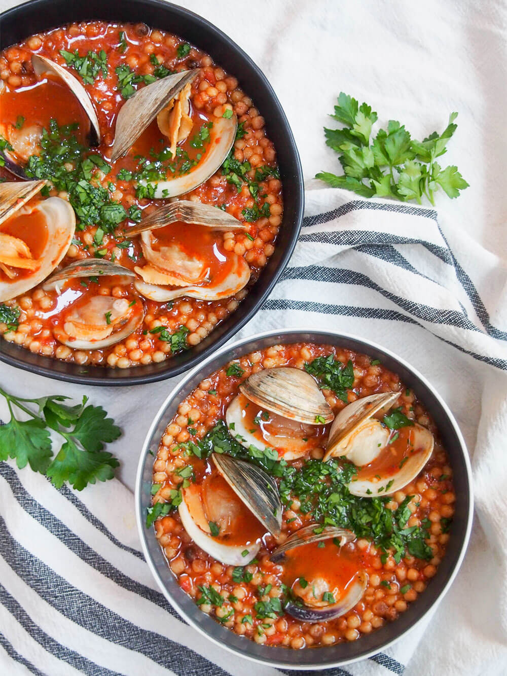 Sardinian fregola with clams in two bowls viewed from overhead