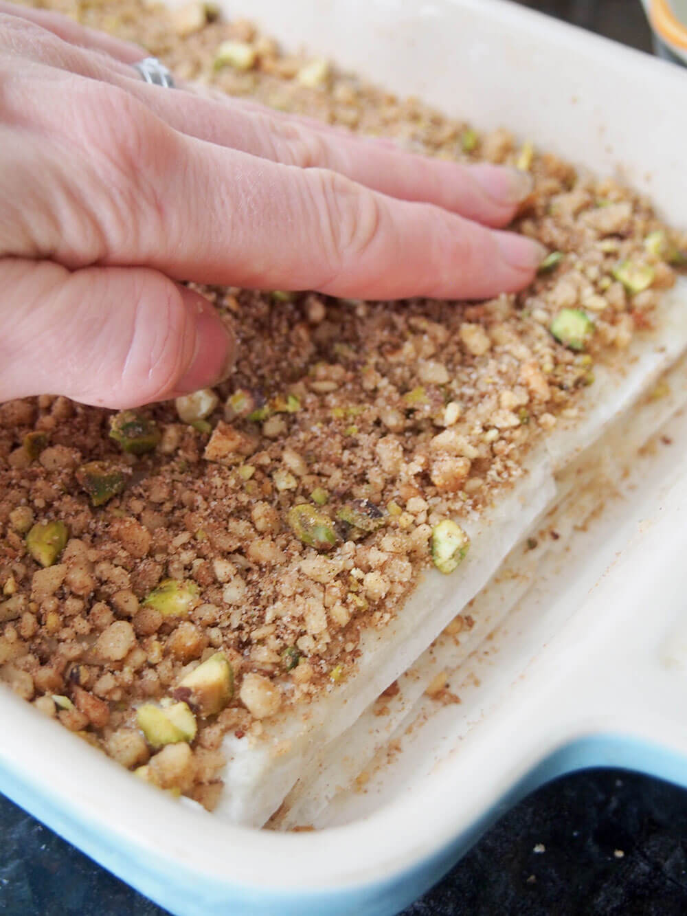 adding layer of nuts to baklava