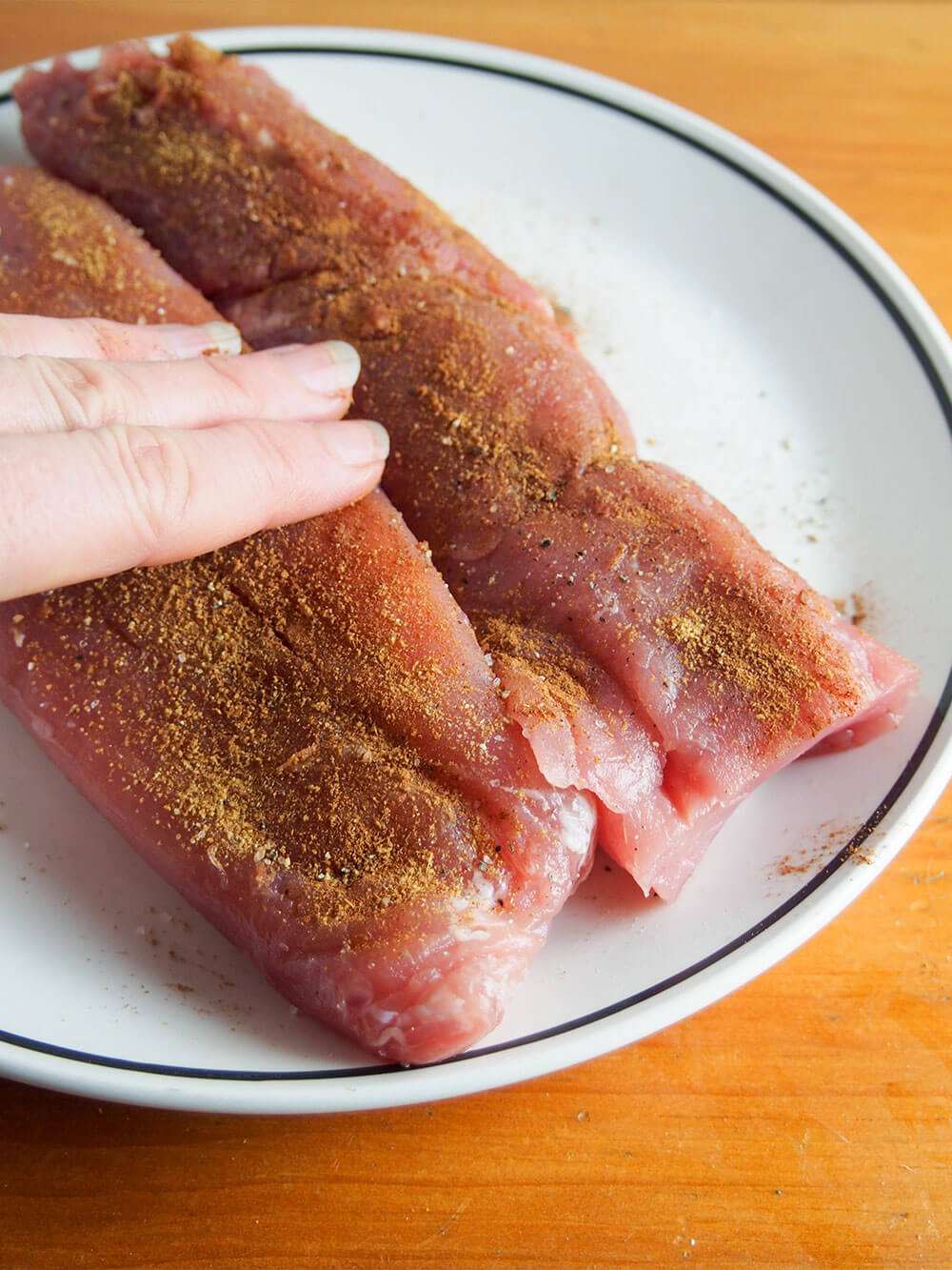 adding rub to pork tenderloin