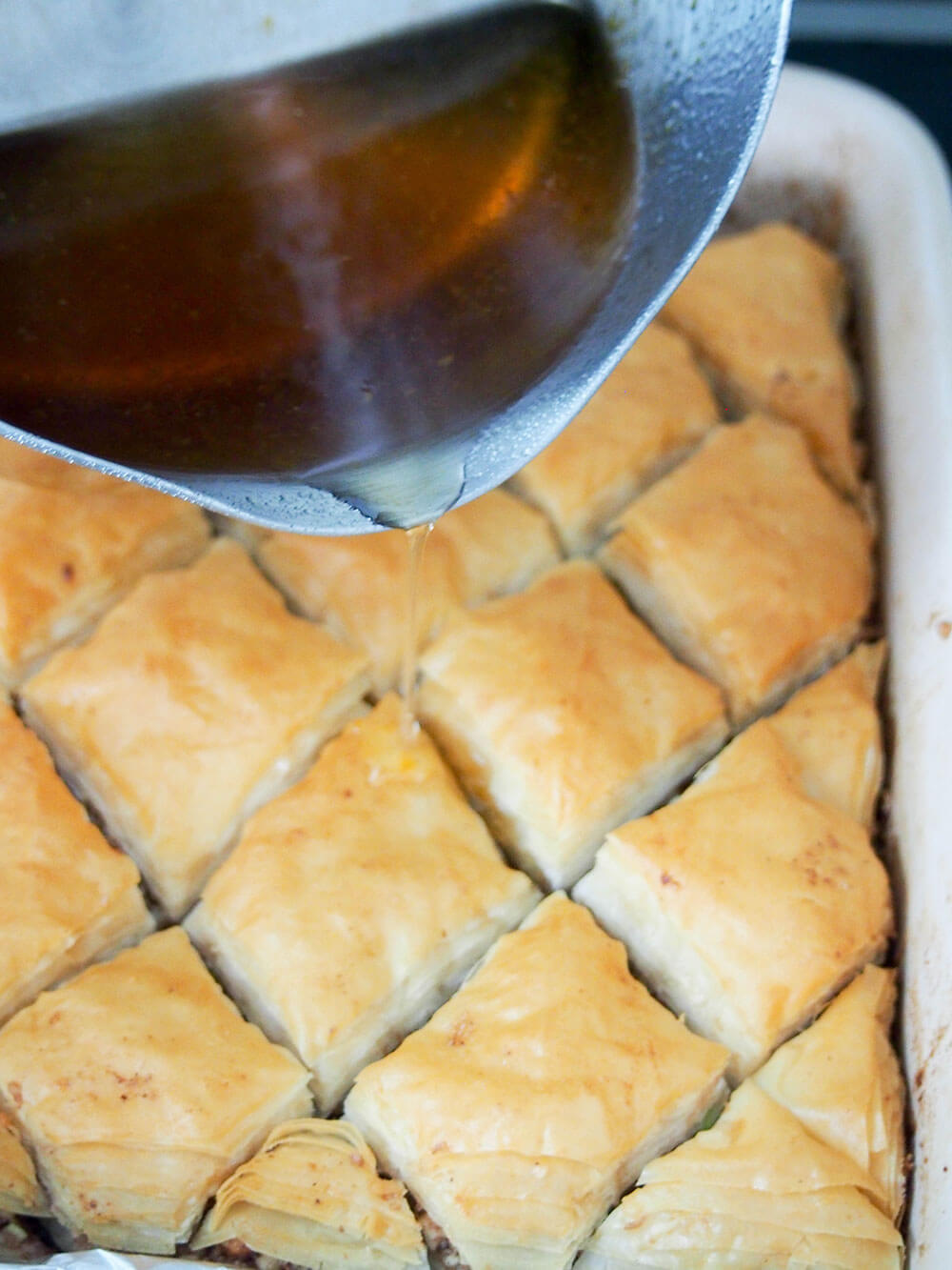 adding syrup to baklava - smaller batch baklava recipe