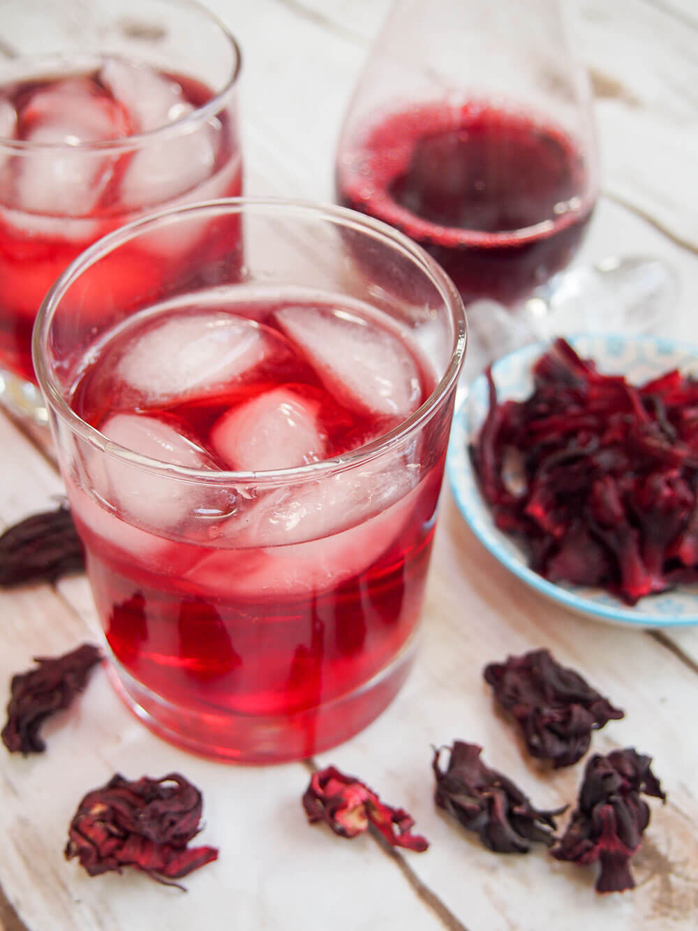 Agua de jamaica - hibiscus tea with flowers and concentrate to side/behind