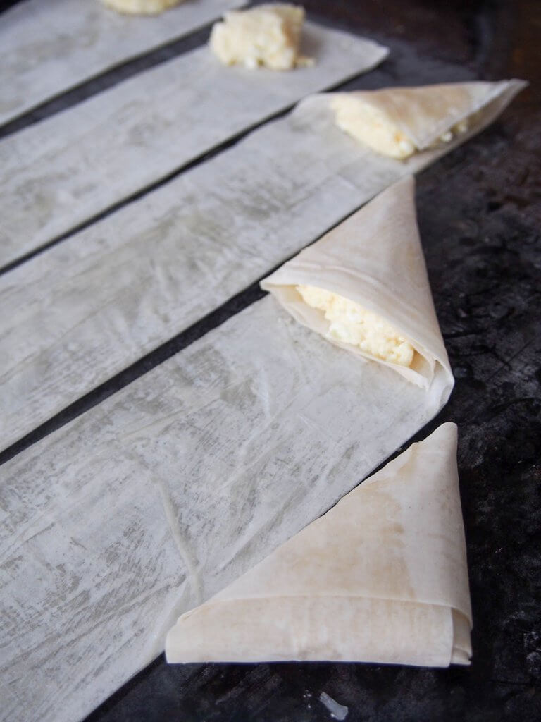different stages of folding tiropita Greek cheese pastries