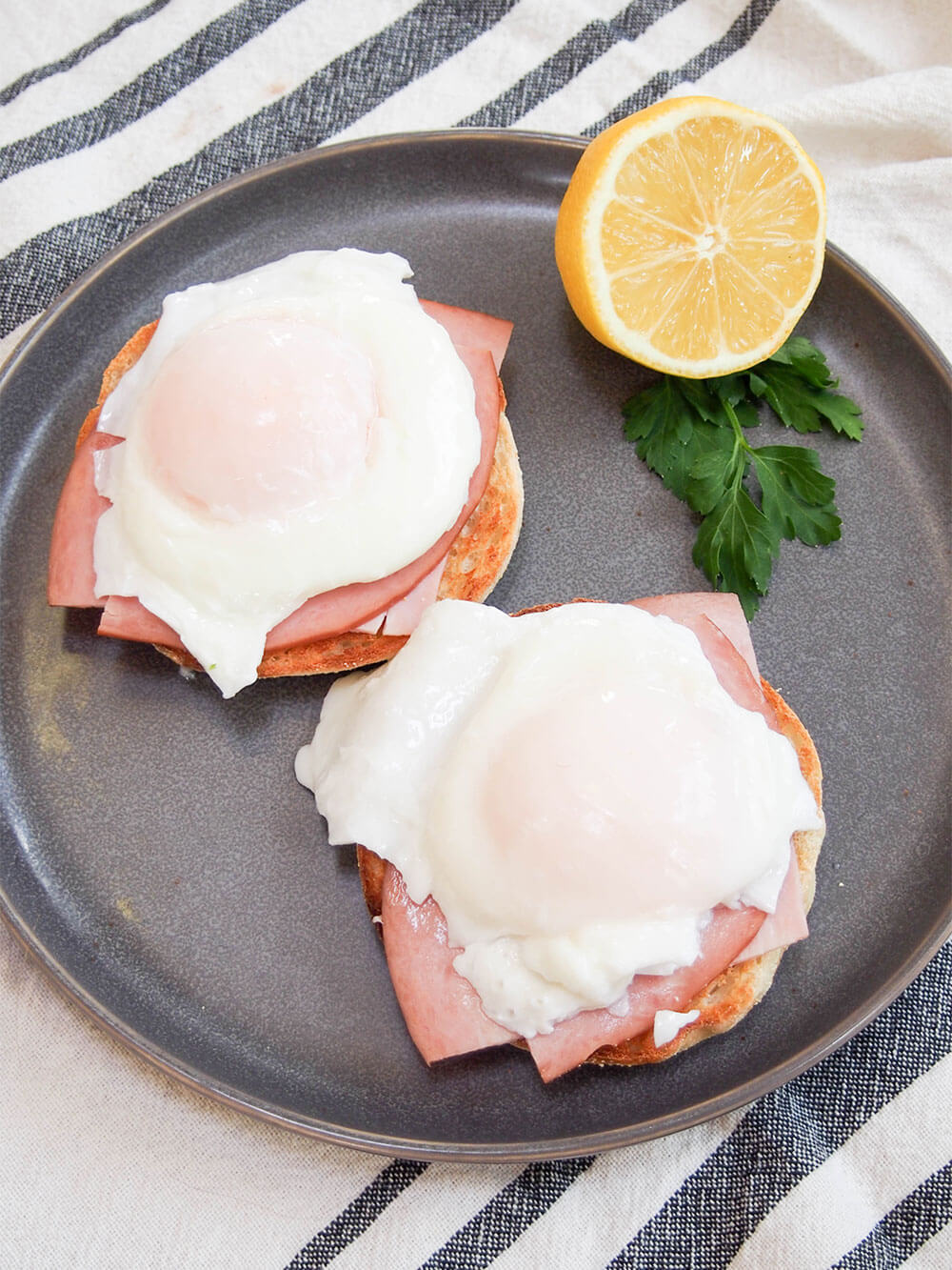poached eggs on top of toasted muffins with ham between