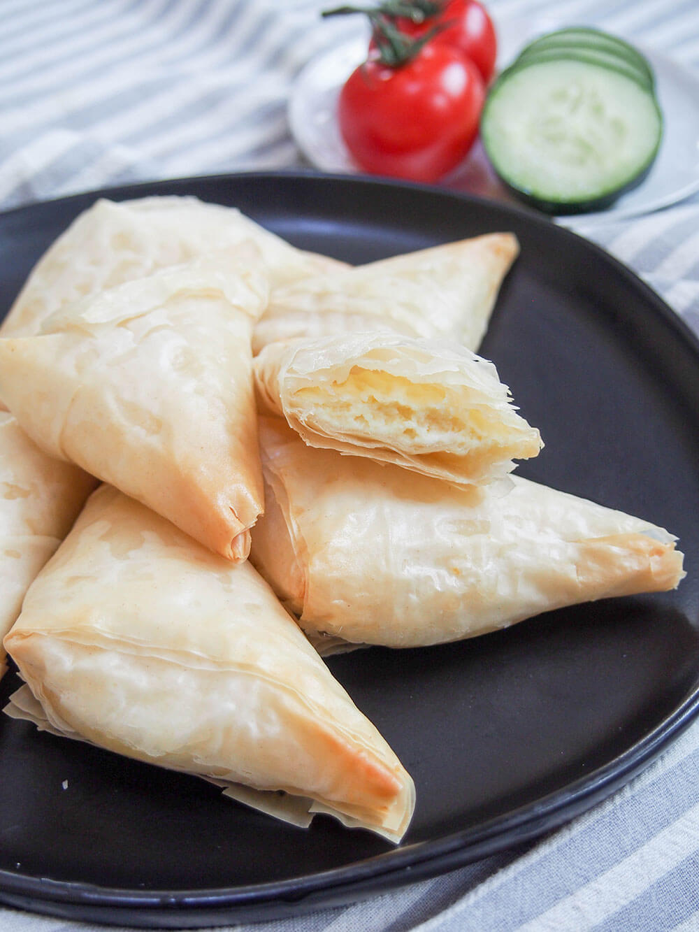 tiropita Greek cheese pastries on plate with one split open resting on another